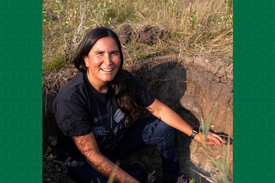 Melissa Arcand is sitting in a large hole out in a field