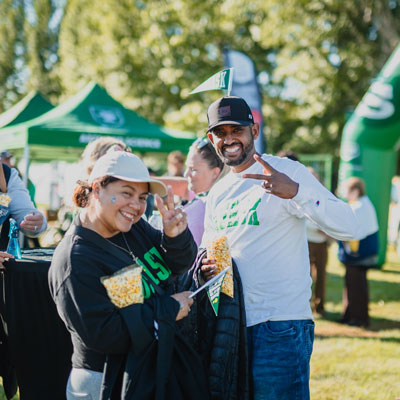 Couple in USask clothing with USask pennant