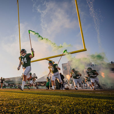 Huskie football players running on to the field
